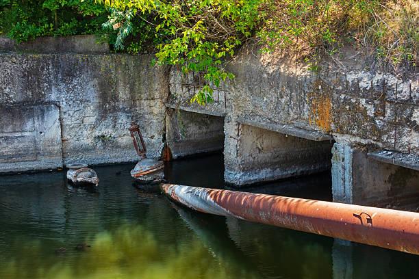 istock Old concrete dam with tunnels for water drainage and rusty pipe 2237730609