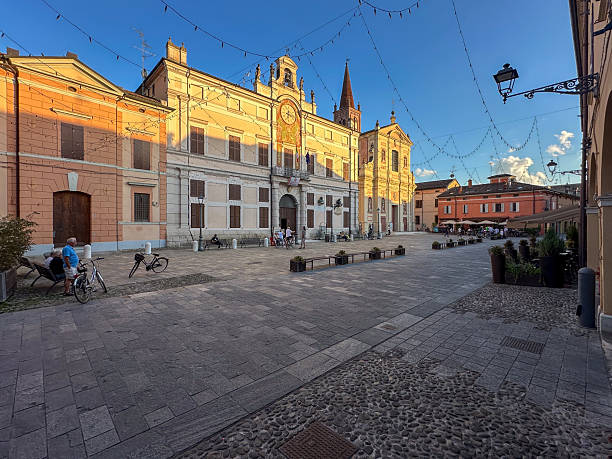 Pieve di Cento (BO), Italy September 21,  2025 - View of the historic center with residents strolling by or simply meeting in the main square at sunset during daily life