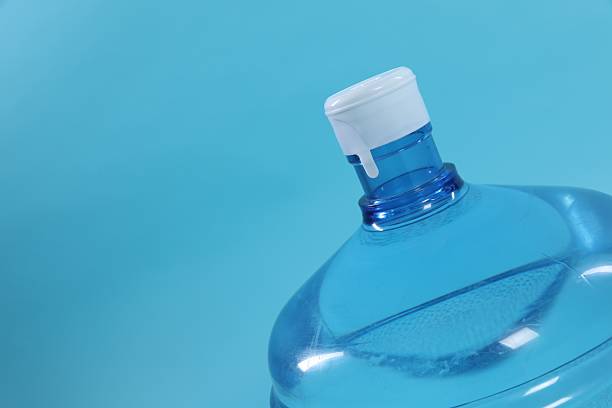 istock Cooler bottle with water on light blue background, closeup. Space for text 2237746458