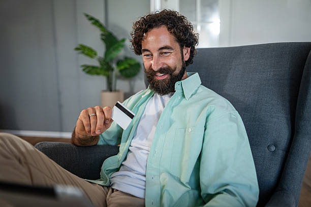 istock Man shopping online using credit card at home 2237747178