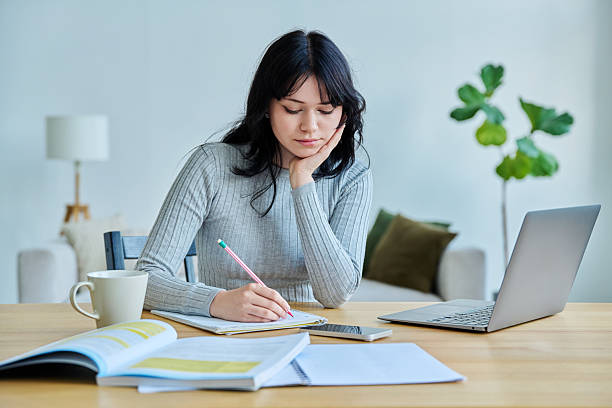 istock Young woman university student sitting at desk with laptop, typing writing studying 2237749056