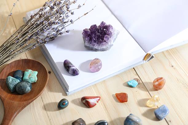 istock Different healing stones, book and lavender on wooden table, closeup 2237757140