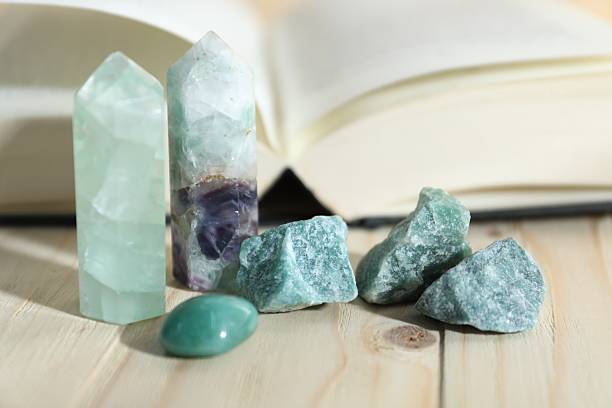 istock Different healing stones and book on wooden table, closeup 2237757142