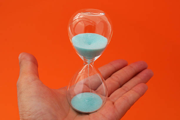istock Passage of time, hand holding an hourglass 2237757314