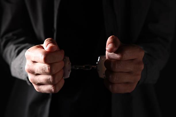 istock Man in metal handcuffs on black background, closeup 2237757480