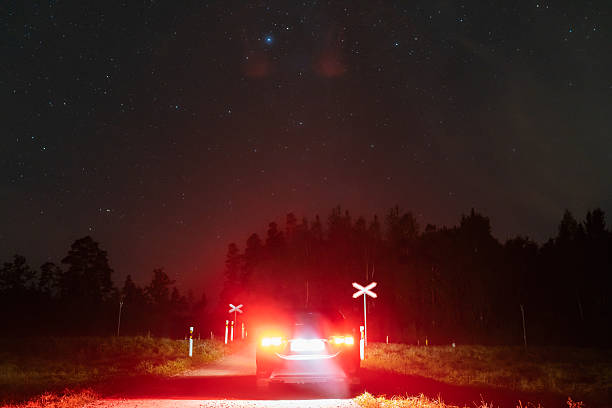 istock A car with red tail lights stops at a rural railroad crossing under a starry night sky in Estonia. 2237761306