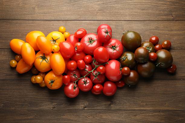 istock Many different ripe tomatoes on wooden table, flat lay 2237761778