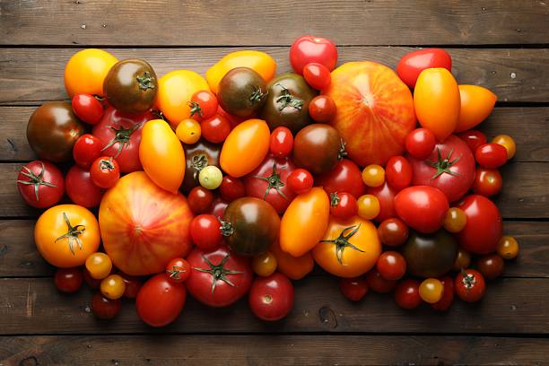 istock Many different ripe tomatoes on wooden table, flat lay 2237761781