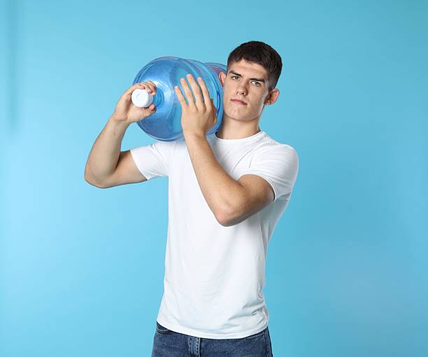 istock Delivery man with cooler bottle of water on light blue background 2237762793
