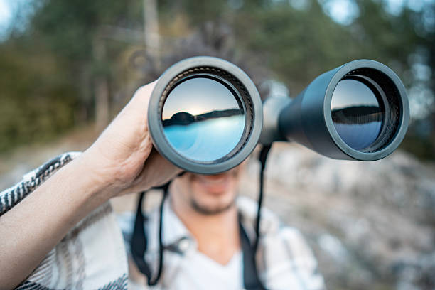 istock Man With Binoculars Exploring Outdoors, Looking Through Twin Lenses in Nature 2237764092