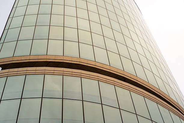 Modern skyscraper with curved glass facade against a light sky