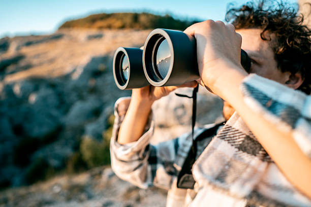 istock Person Using Binoculars Outdoors During Sunset on Rocky Terrain—Adventure, Nature, and Exploration 2237774491