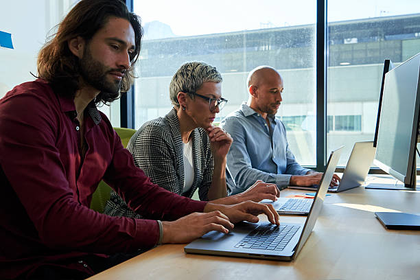 istock Three multiracial business colleagues sitting in the office working using laptops. 2237777627