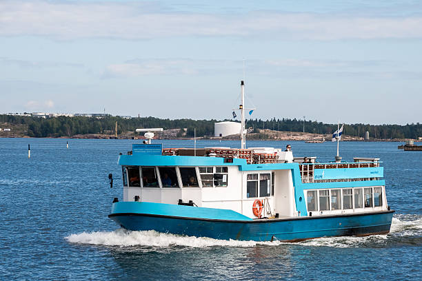 Helsinki, Finland - September 02, 2014 - Blue and white ferry navigating calm waters against scenic coastline.