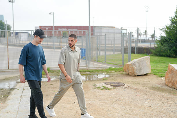 istock Two men walking in a park, one wearing a black hat 2237802518