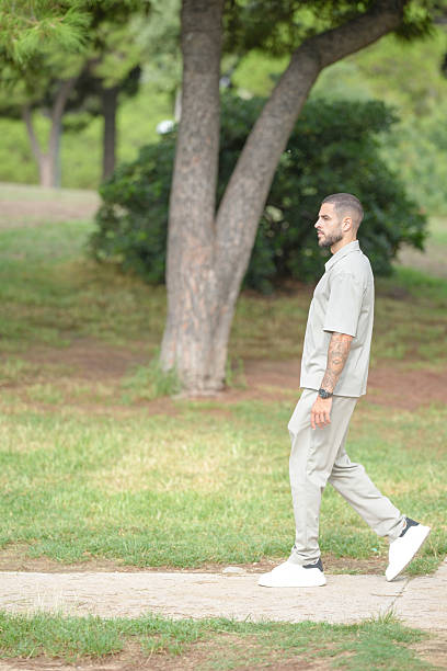 istock A man is walking in a park with a tree behind him 2237803068