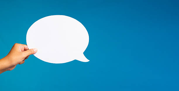 istock Hand holding blank round speech bubble cutout on blue background for communication and dialogue concept. 2237805848