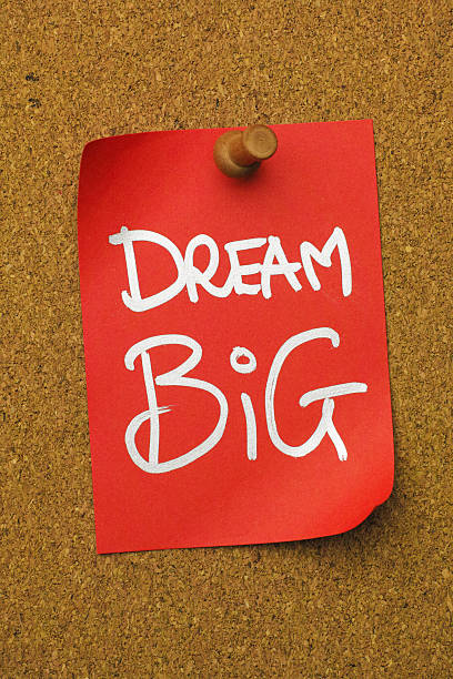 istock Red paper note pinned to a cork message board, with the short phrase 'DREAM BIG' written on it. 2237810780