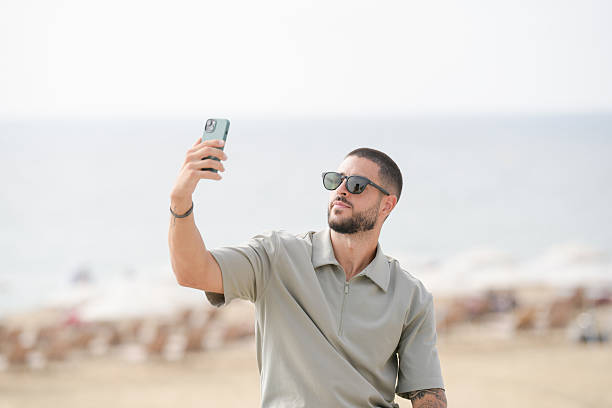 istock A man is taking a selfie with his cell phone while standing on a beach 2237812418