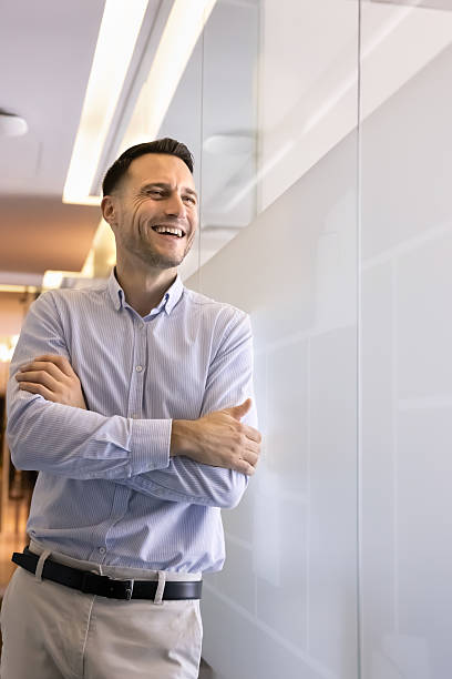 istock Smiling millennial businessman standing in office hallway 2237814850