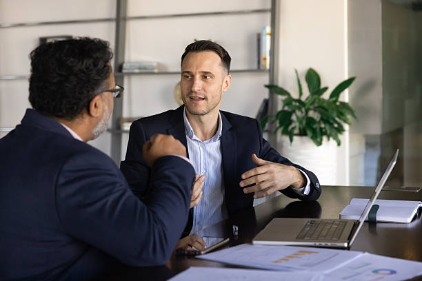 istock Two professionals in suits engaged in discussion at modern office 2237816302