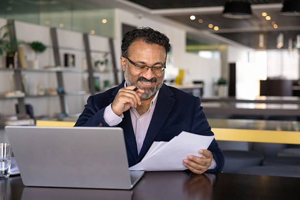 istock Smiling Indian businessman in jacket reviewing documents 2237822398