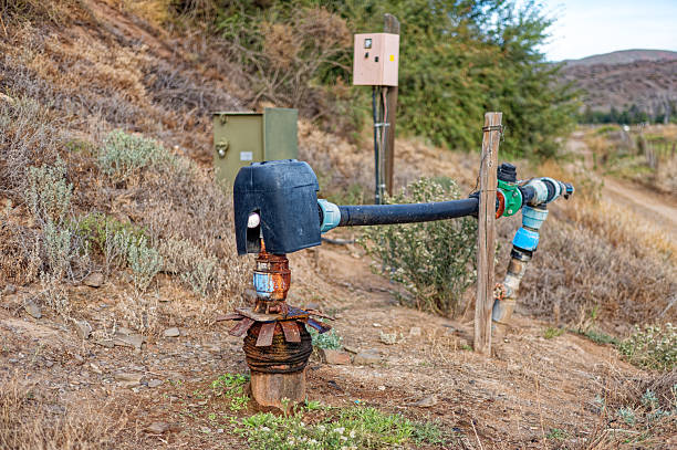 Agricultural sprinkler watering the green  meadow in Alps