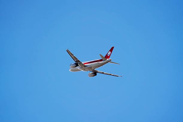 This dynamic aerial view captures a sleek white commercial passenger jet  soaring gracefully through an endless vibrant blue sky, evoking a sense of freedom, adventure, and global connectivity. The sharp details of the wings, engines, and fuselage highlight modern aviation elegance, perfect for travel campaigns, airline promotions, business lifestyle visuals, or inspirational sky-high concepts in advertising, editorial, or social media content.