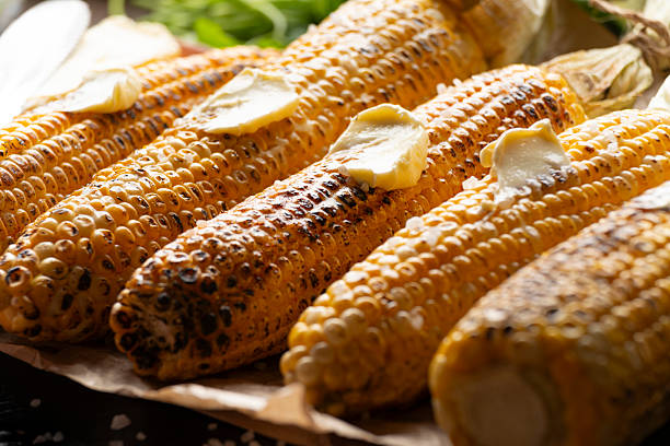 istock Grilled sweetcorn cobs with butter on the table closeup low angle view 2237837235
