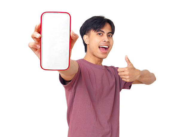 istock Happy excited young Asian man showing blank smartphone screen while giving thumbs up on plain background, perfect for digital ads, app promotion, and marketing design. 2237838739