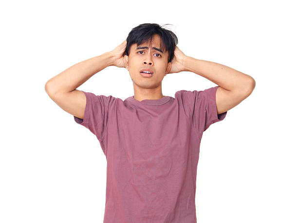 istock Stressed young man holding head with worried face, looking frustrated and anxious on plain background, ideal for mental health, problem, and lifestyle concepts. 2237838818