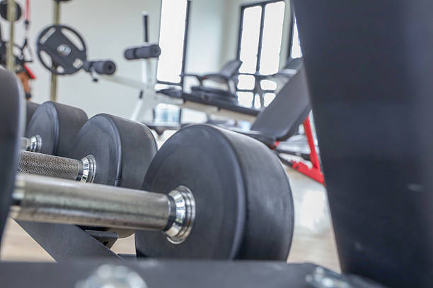Assorted dumbbells of different weights neatly arranged on a gym rack, prepared for use in a strength training session. Fitness equipment and concept. Object goal weightlifting bodybuilding.