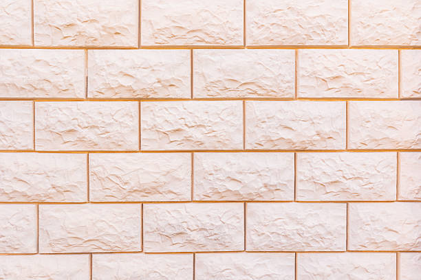 Abstract background of laying a beige brick wall. brick texture in a light tone. A blank layout for design. A copy space. A sample of a brick wall.