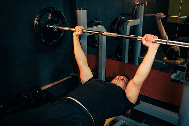 istock Man Lifting Barbell in Gym While Bench Pressing 2237841041