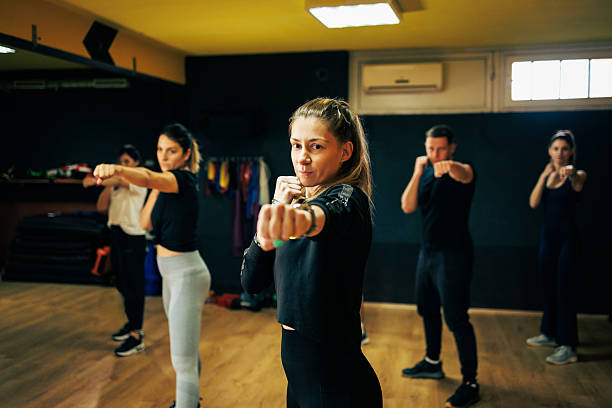 istock Group Fitness Class: Focused People Punching Forward in Gym During Boxing Training 2237841437