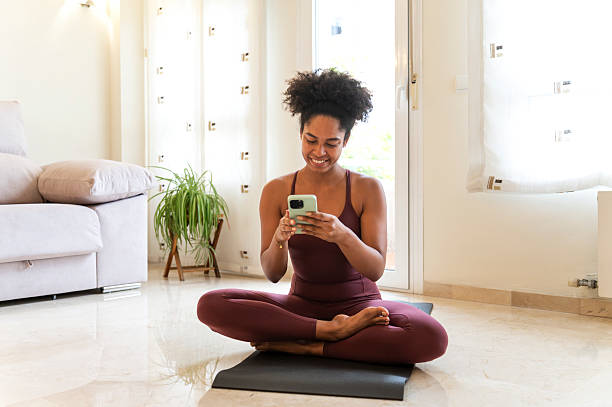 istock Woman taking a break on yoga mat using smartphone 2237841811