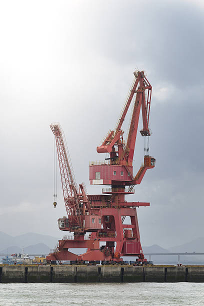 istock Red Cranes at the Port Under a Cloudy Sky 2237842929