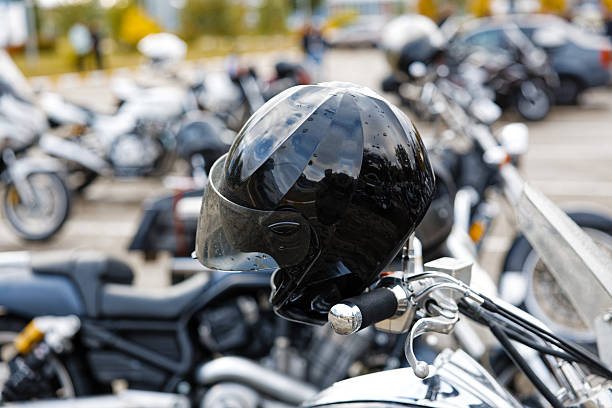 istock Closeup black moto helmet on motorcycle handlebars against blurred background 2237845066