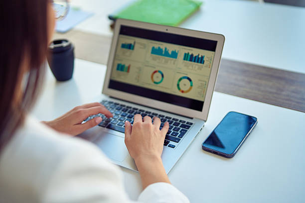 istock Woman actively using laptop with business charts on screen 2237854674