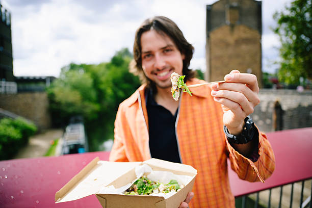 istock Man holding fork with food up towards camera, focus on foreground 2237855892