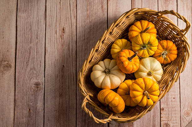 istock Autumn pumpkins background. Orange and white mini squashes in a basket. 2237869411