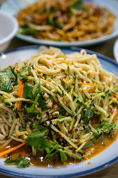 istock Thai-Style Cold Noodle Salad with Cilantro and Peanuts, Garnished with Fresh Vegetables and Spicy Sauce 2237877110