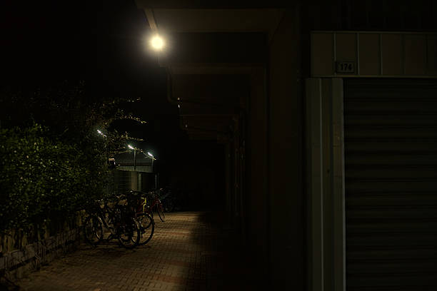 The bicycle is parked on the road at night