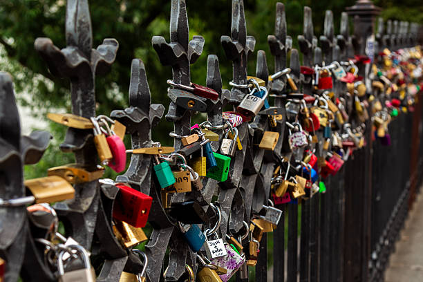 Dozens of colorful padlocks attached to an ornate iron fence, symbolizing love and commitment in a romantic outdoor setting.