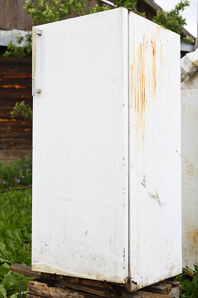 istock Old rusted refrigerator standing on a wooden pallet in a rural setting 2237880343