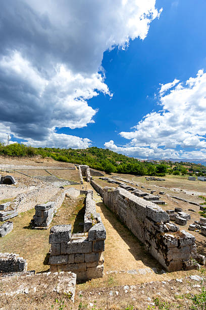Roman ruins of Amiternum showing ancient stone structures and a blue sky with white clouds