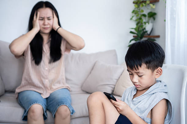 istock boy playing games on his smartphone while his bored and angry mother 2237884716