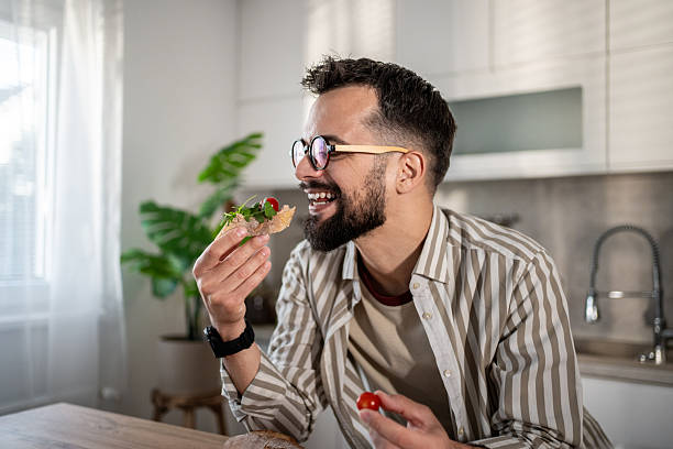 istock Man enjoying healthy sandwich for breakfast in kitchen 2237890606
