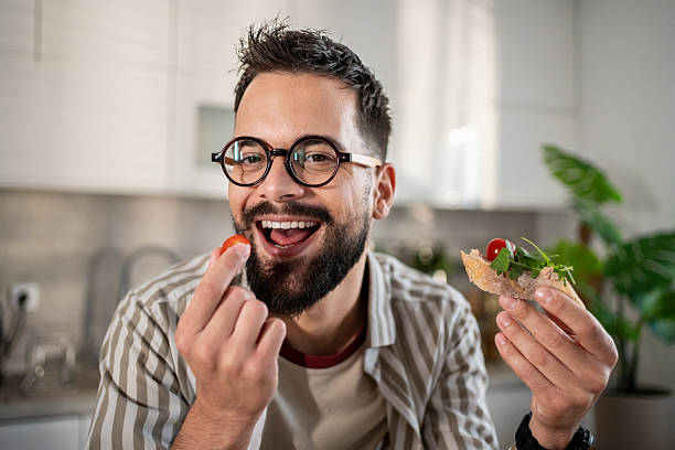 istock Man eating bruschetta with cherry tomato and smiling 2237890611