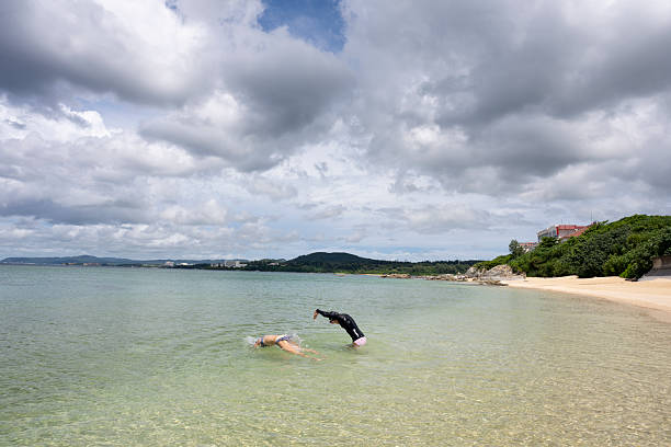 27 March 2025, Da Nang - Vietnam.Group of young tourist is swimming in South China sea at Da Nang, enjoying the city’s long coastline. Beaches like My Khe and My An are popular favorites for both relaxation and recreational activities.